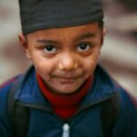 Captivating close-up portrait of a young boy in traditional attire from Nepal.